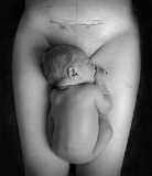 neonato sulle gambe della mamma