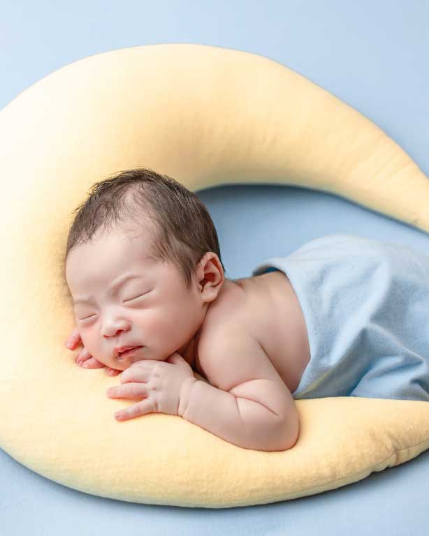 neonato che dorme su un cuscino a forma di stella